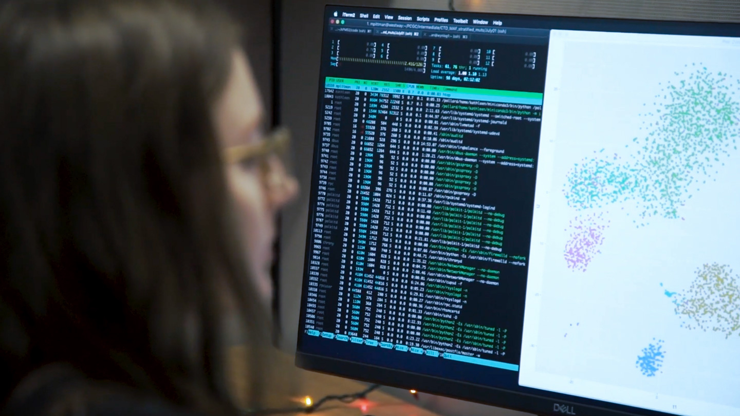 Woman looking at a computer with data on the screen