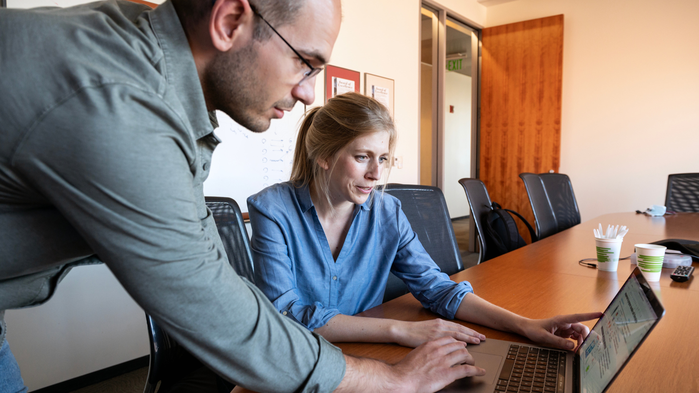 Gladstone's Franziska Blaeschke and Stanford’s Theo Roth look at data on a laptop  at Gladstone Institutes