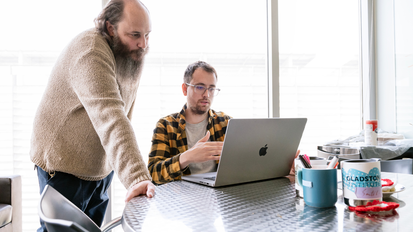 Seth Shipman and Alejandro González-Delgado looking at data on a computer at Gladstone Institutes