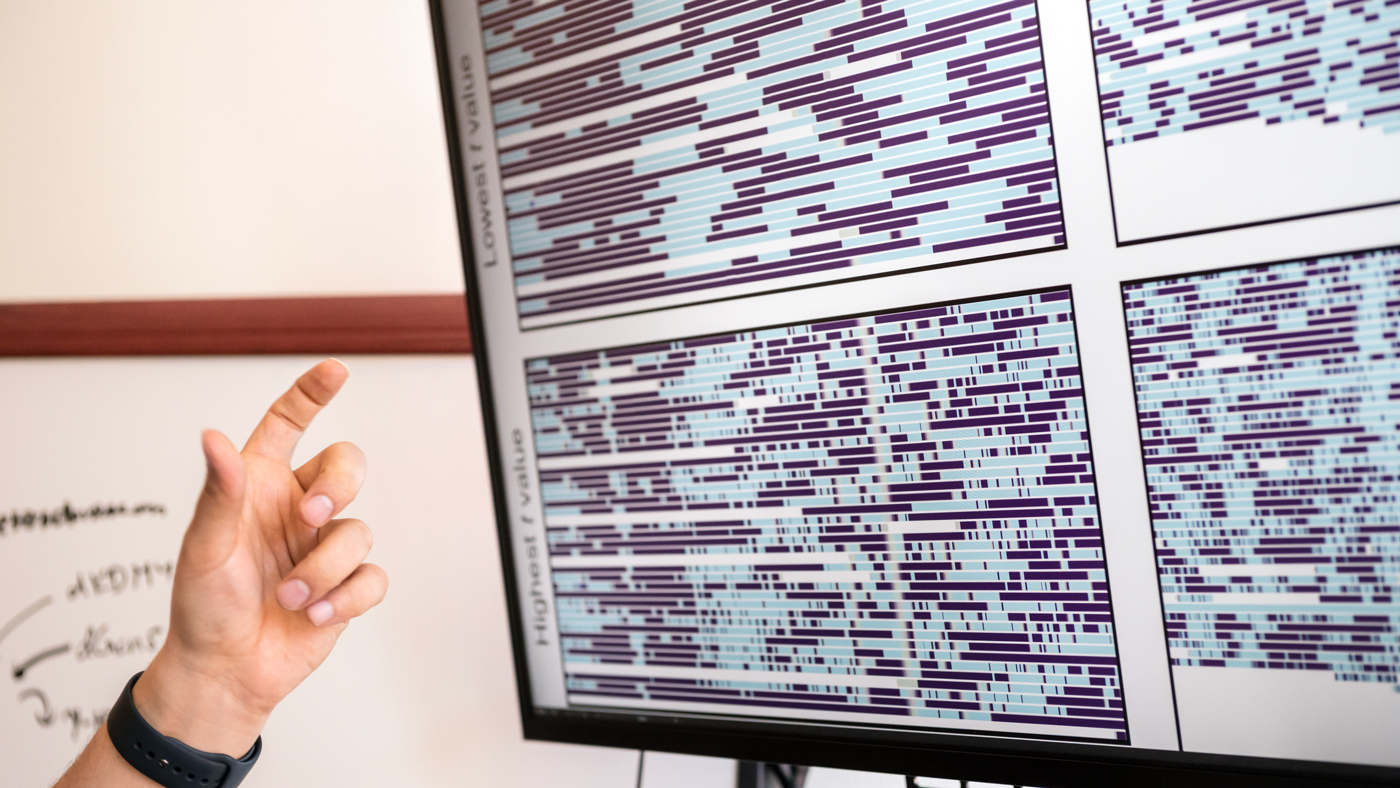 Hani Goodarzi pointing at a monitor in Vijay Ramani's office at Gladstone Institutes