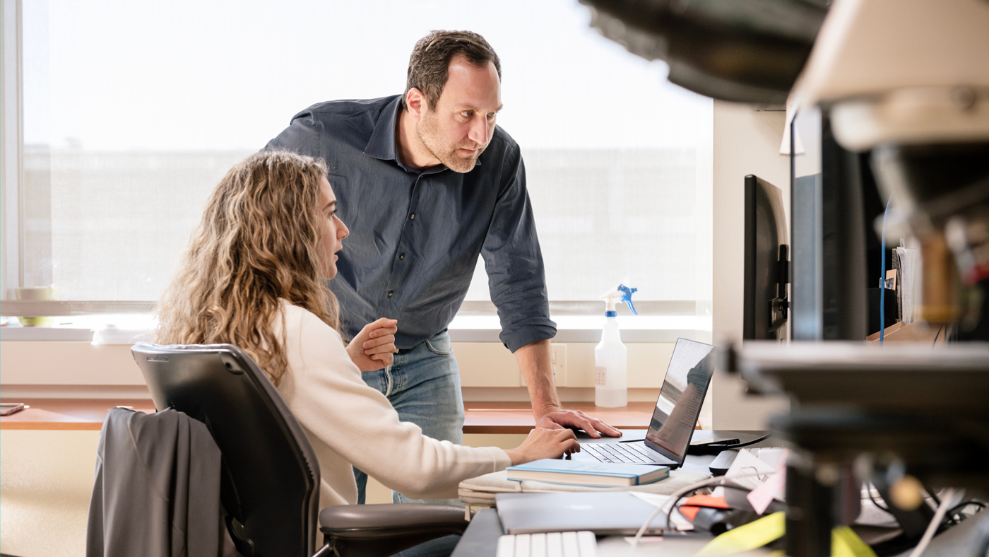 Alex Marson reviews data on a computer screen with an associate