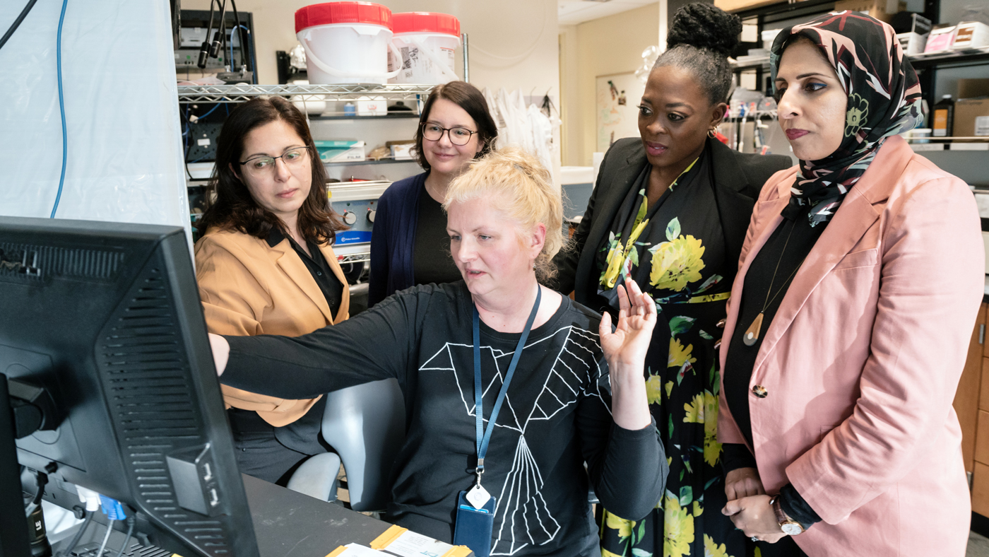 A group of scientists at Gladstone Institutes review data in the lab of Jeanne Paz