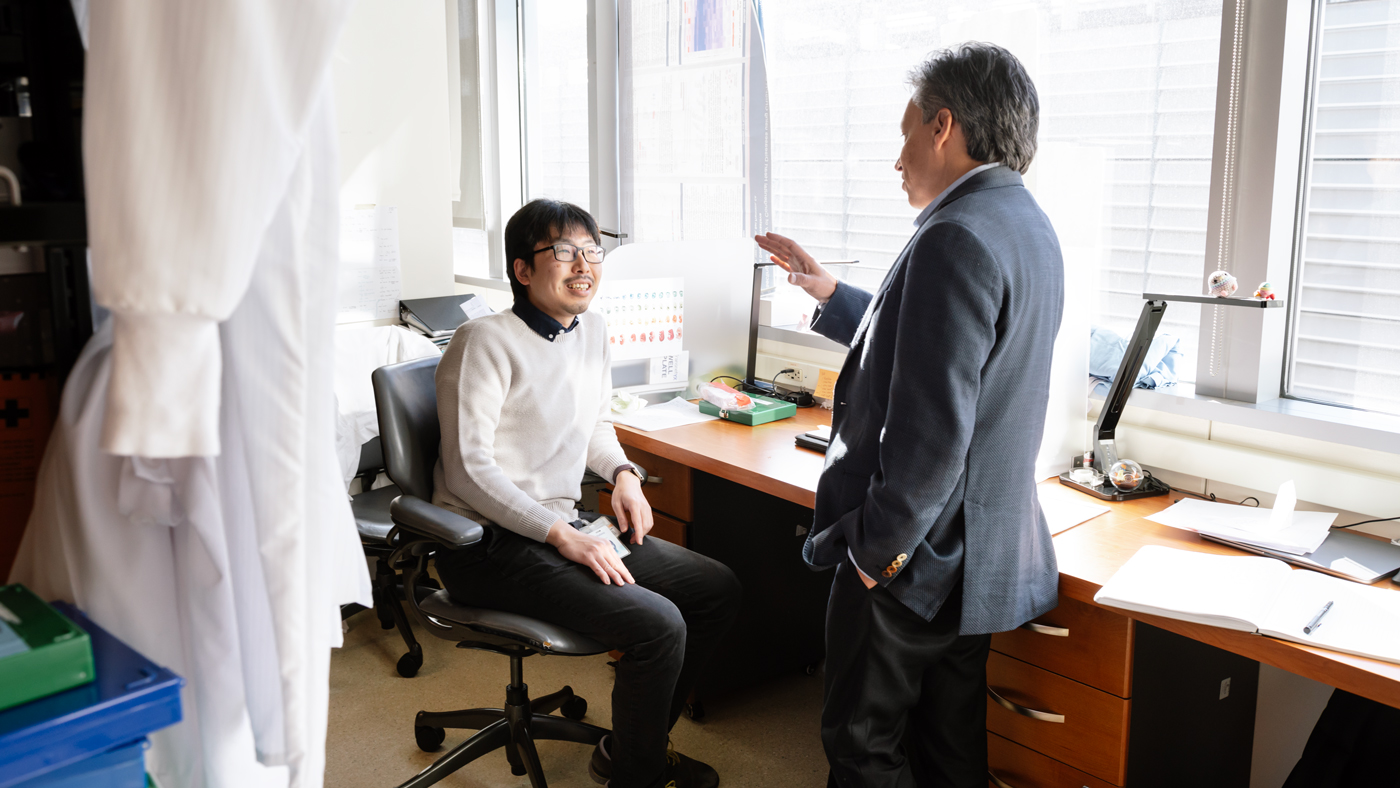 Tomohiro Nishino, MD, PhD, a Gladstone postdoctoral scholar and first author of the study, speaks with senior author Deepak Srivastave, MD