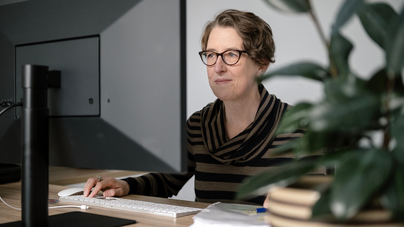 Katie Pollard working at a computer at a desk at Gladstone Institutes