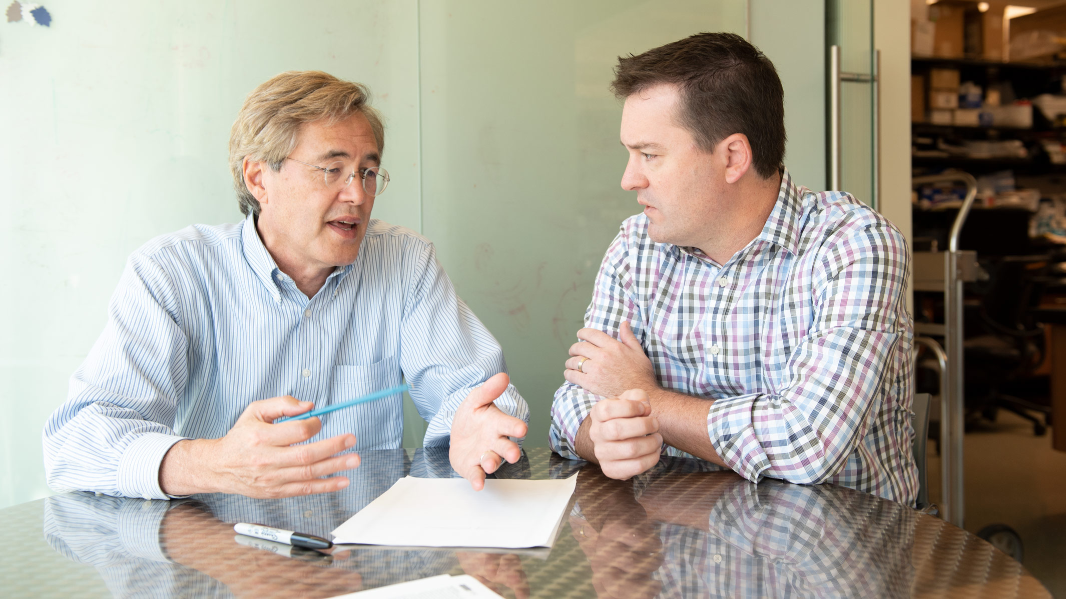 Bruce Conklin and Todd McDevitt sitting and talking at a table