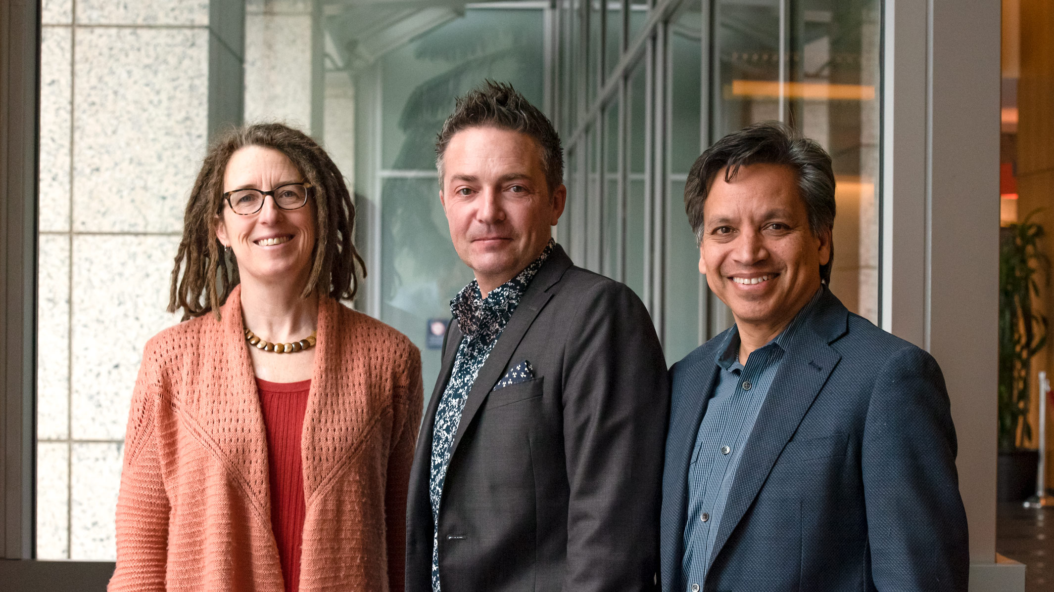 Katie Pollard, Benoit Bruneau, and Deepak Srivastava posing for a photo in the Gladstone lobby